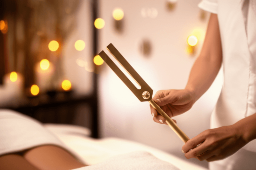 Eine Nahaufnahme von präzisionskalibrierten Acutonics-Stimmgabeln, die sanft auf Akupunkturpunkten auf einem Arm platziert werden, in einem ruhigen Wellness-Studio. Markenlogo von Soul Art und der Name Larissa Steinbach sind subtil im Bild platziert, um die Exzellenz der Klangtherapie zu betonen.